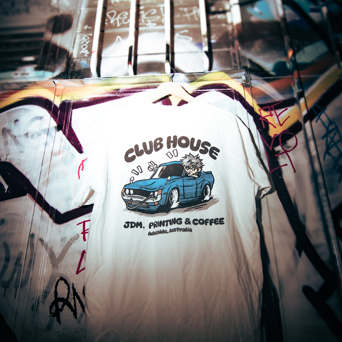 Chibi Club RA23 Celica JDM T-shirt displayed in an urban setting